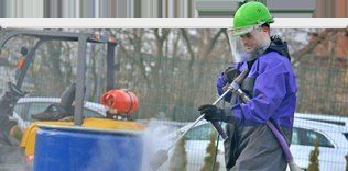 Limbach-Mitarbeiter in Schutzkleidung bei Hochdruck-Wasserstrahlarbeiten
