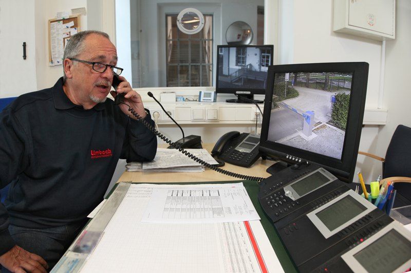 Limbach-Mitarbeiter am Empfang mit Monitoren und Telefonanlage